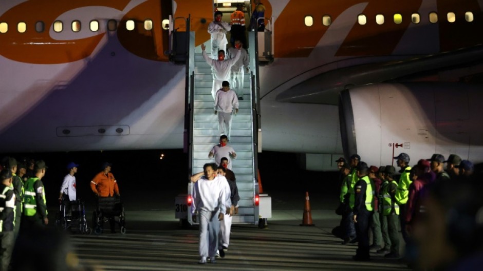 Venezuelan migrants deported from US Naval Station Guantanamo Bay walk down from the Venezuelan Conviasa Airlines plane as they arrive at Simon Bolivar International Airport in Maiquetia, Venezuela on February 20, 2025