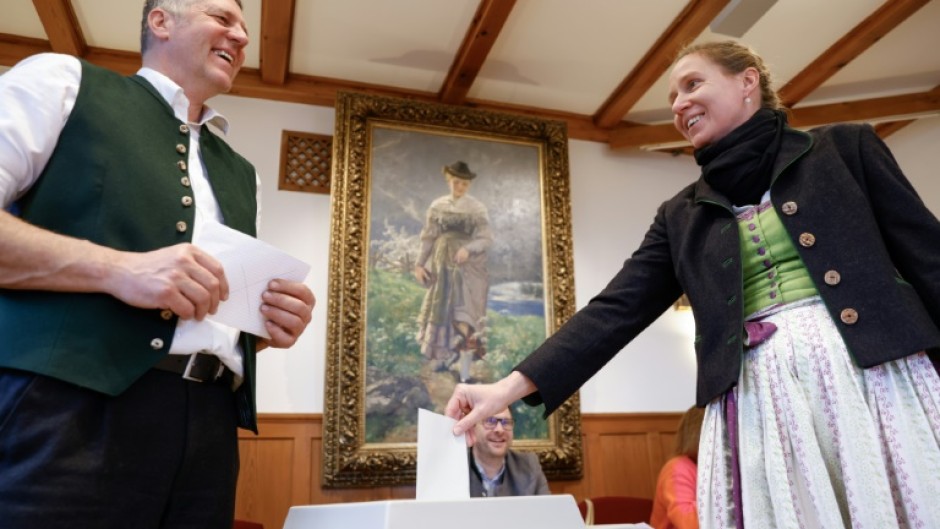 A voter wearing a traditional Bavarian dress casts her ballot in Kochel, southern Germany