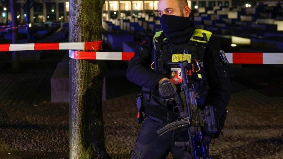 An armed police officer at the cordoned off scene of the stabbing attack