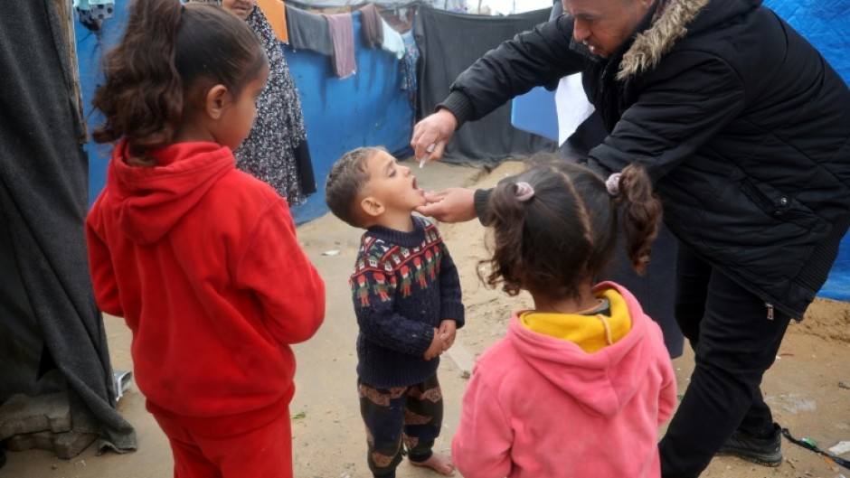 A Palestinian child at a camp for displaced people in Nuseirat, central Gaza, receives a polio vaccine in the third mass polio vaccination campaign for the territory