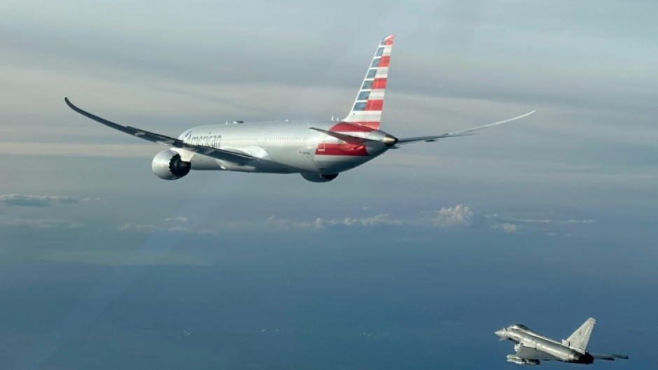 This handout picture taken and released by the Italian Air Force shows the American Airlines flight being escorted by a fighter jet