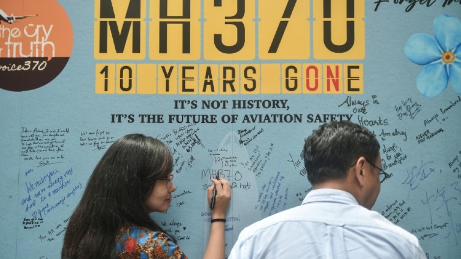 A woman writes a message during an event to mark the 10th year since the Malaysia Airlines flight MH370 disappeared on March 8, 2014