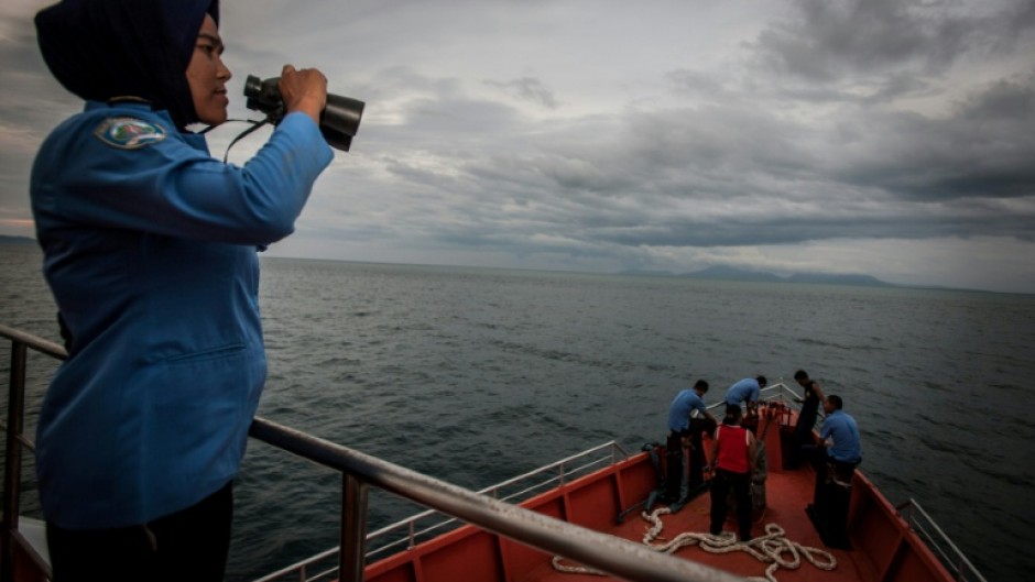 A member of Indonesia's National Search and Rescue looks over horizon during a search for the missing Malaysian Airlines MH370 plane on March 17, 2014