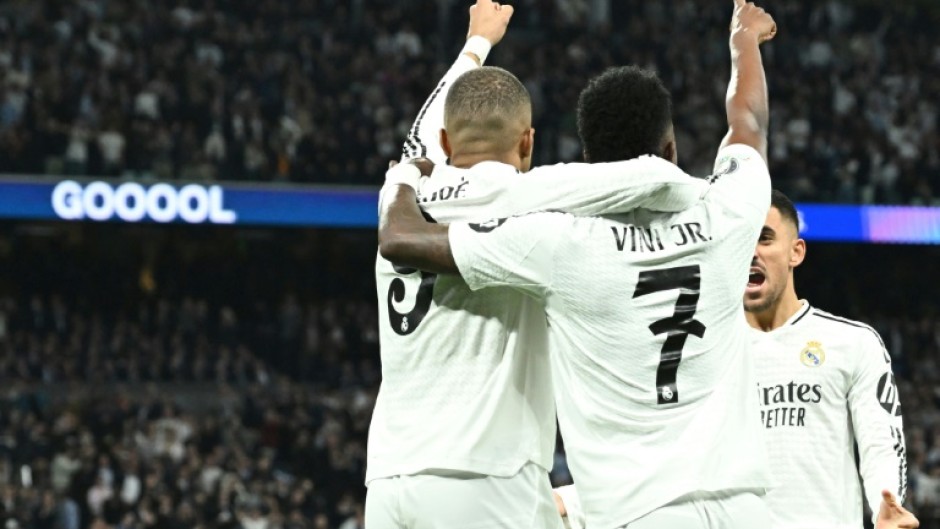 Real Madrid's French forward Kylian Mbappe (L) celebrates with Vinicius Junior during the win over Man City