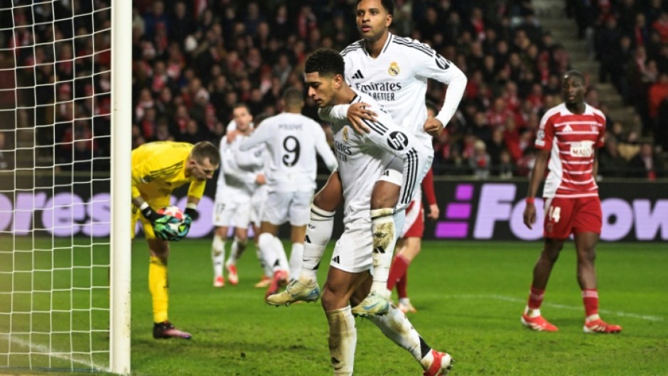 Real Madrid's English midfielder Jude Bellingham celebrates with teammate Rodrygo (top)