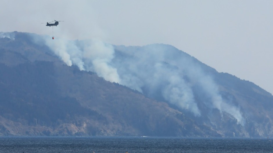 A helicopter is pictured above the wildfire near Ofunato