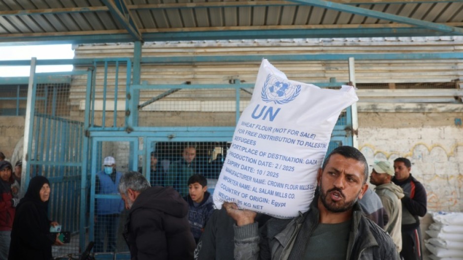 A Palestinian receives food aid from a United Nations distribution centre in Nuseirat refugee camp, central Gaza, after Israel announced a block on aid flows into the territory