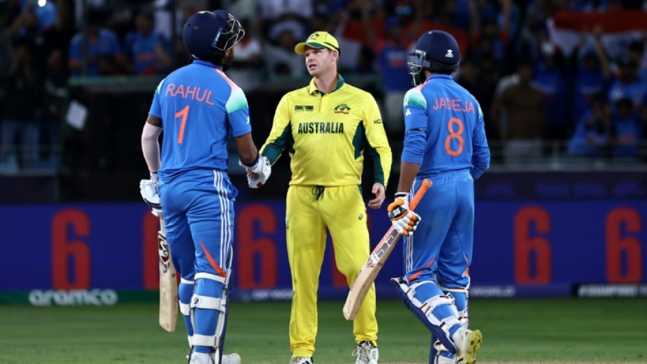 Australia's captain Steve Smith (C) shakes hands with India's KL Rahul