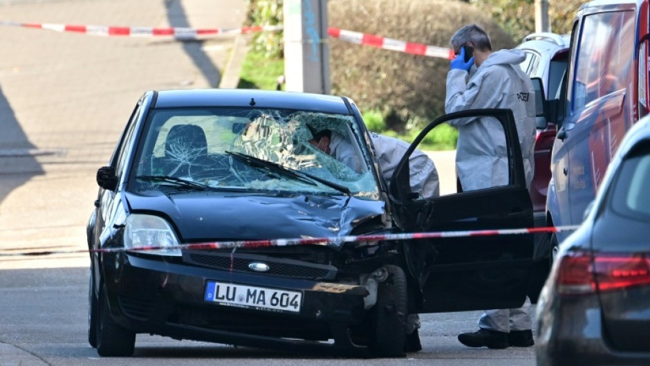 Forensic officers examine the damaged car at the site in Mannheim, southwestern Germany