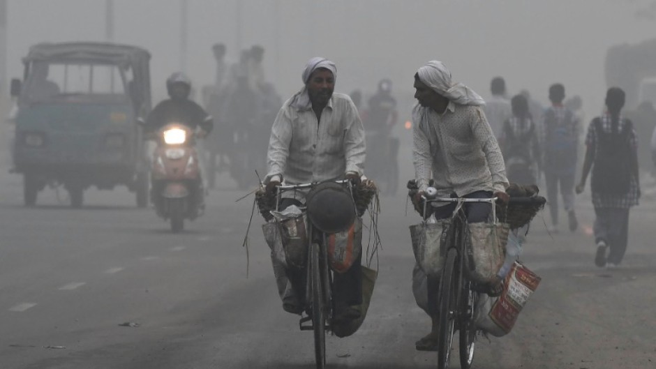 Commuters drive through heavy smog in New Delhi on November 2017