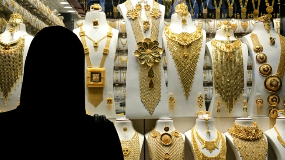 A woman examines gold jewellery at a shop in Dubai