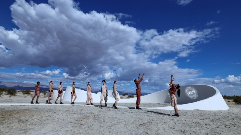 Dancers perform in front of  French-American artist Sarah Meyohas's piece 'Truth Arrives in Slanted Beams' ahead of the opening of the Desert X exhibit spread across California's Coachella Valley 