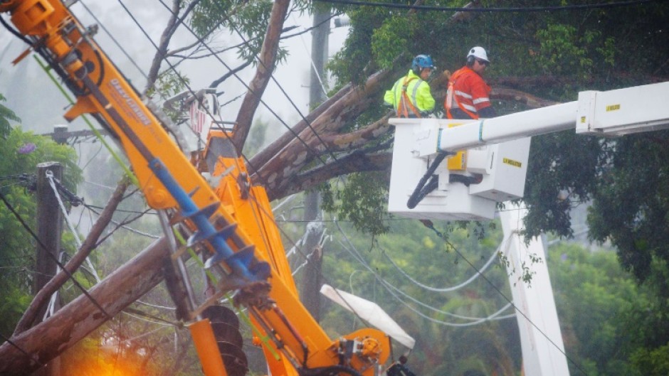 Energex utility crews clear a fallen tree following the passage of tropical cyclone Alfred in Brisbane 
