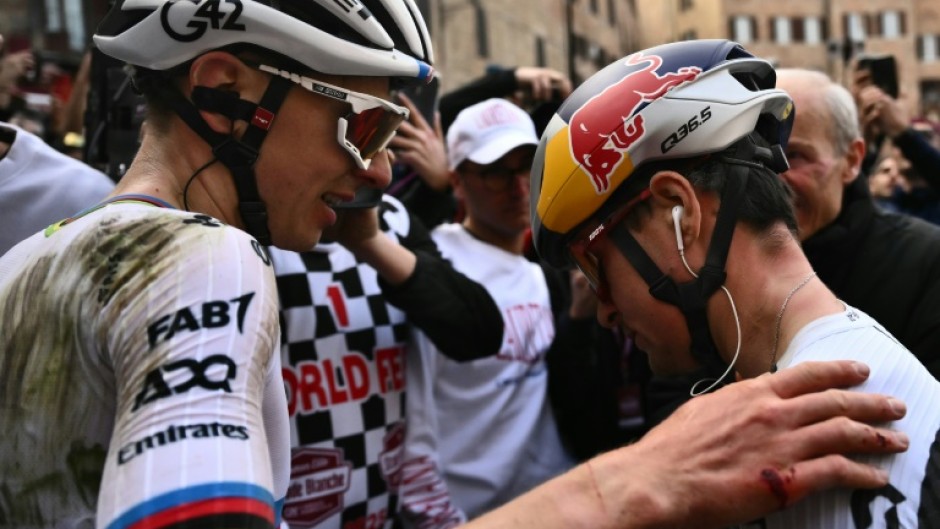 Tadej Pogacar (L) and Tom Pidcock greet each other at the end of the Strade Bianche
