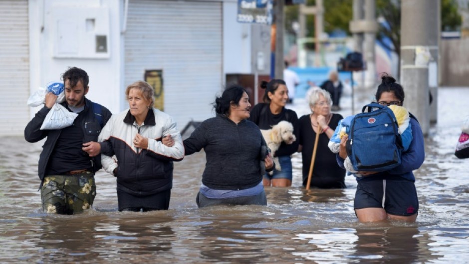 People walk through flood waters in Bahia Blanca, Argentina on March 8, 2025