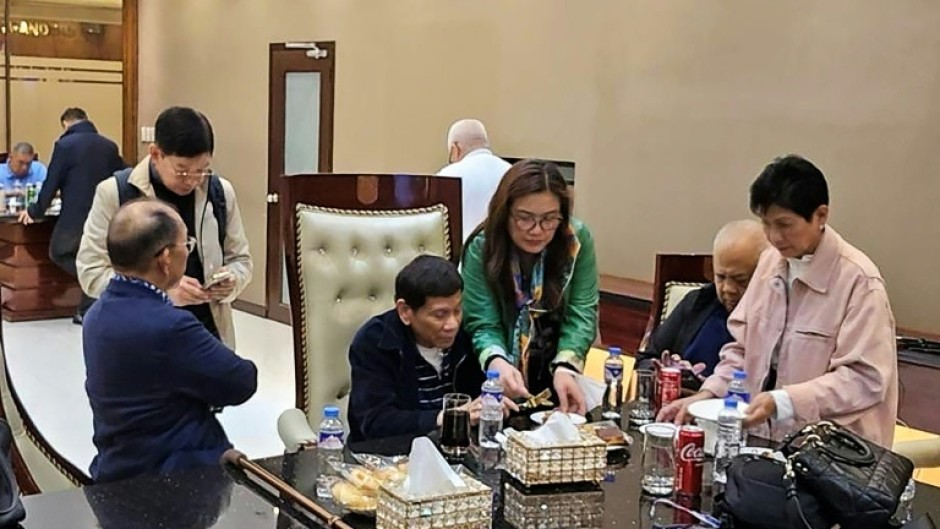 This handout photo taken and released by Rodrigo Duterte's PDP Laban party shows the former Philippine president (C) inside the Villamor Air Base in Manila