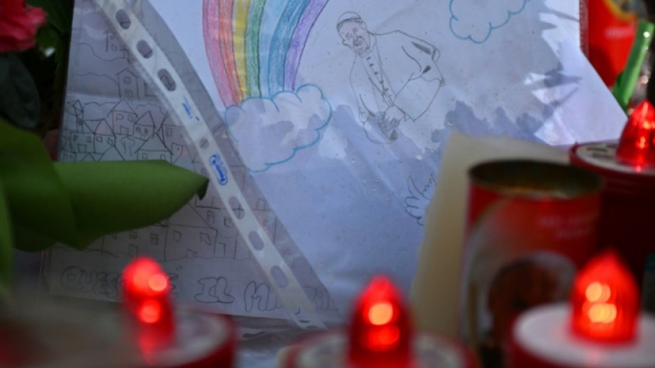 A drawing depicts Pope Francis under a rainbow outside the Gemelli hospital