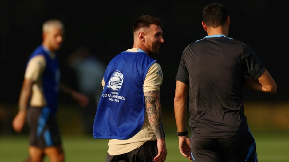 Lionel Messi (C) talks with Argentina head coach Lionel Scaloni (R) 