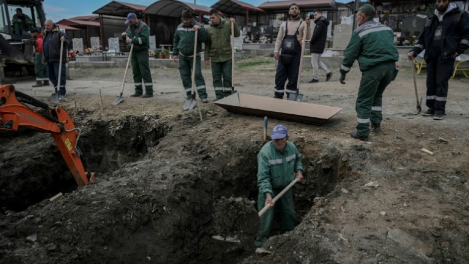 Cemetery workers dug graves on the outskirts of town