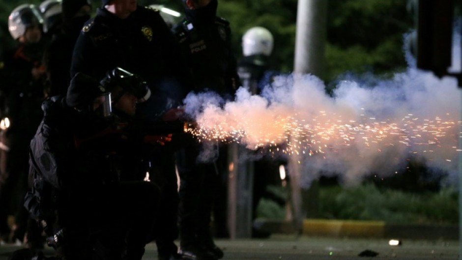 A Turkish riot police officer fires a tear gas canister at students staging a demonstration in Ankara on Thursday