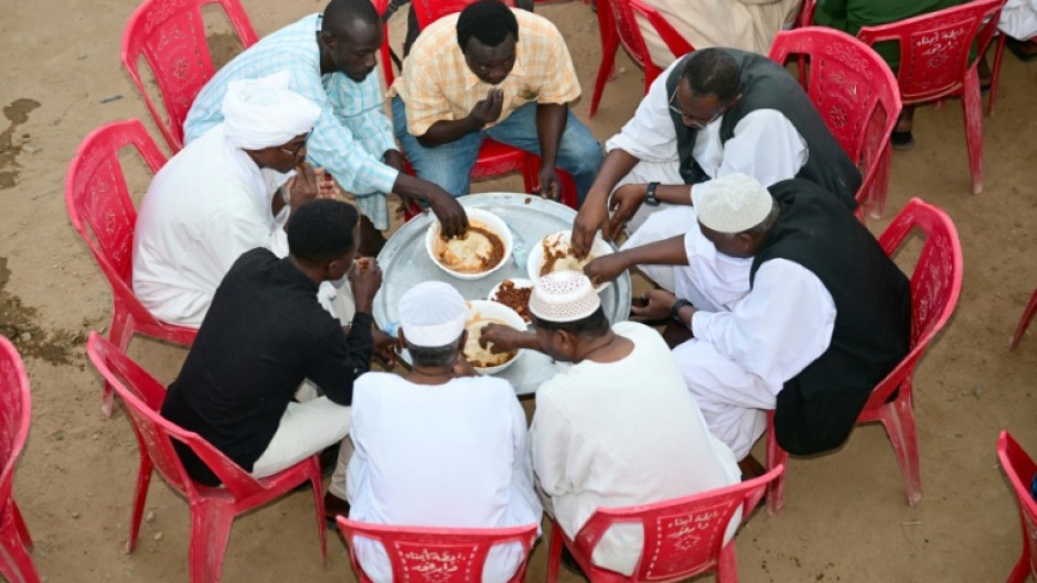 Sudanese, originally from the Darfur region, break their fast during a group iftar fast-breaking meal in the Muslim holy month of Ramadan, in Sudan's de-facto capital of Port Sudan