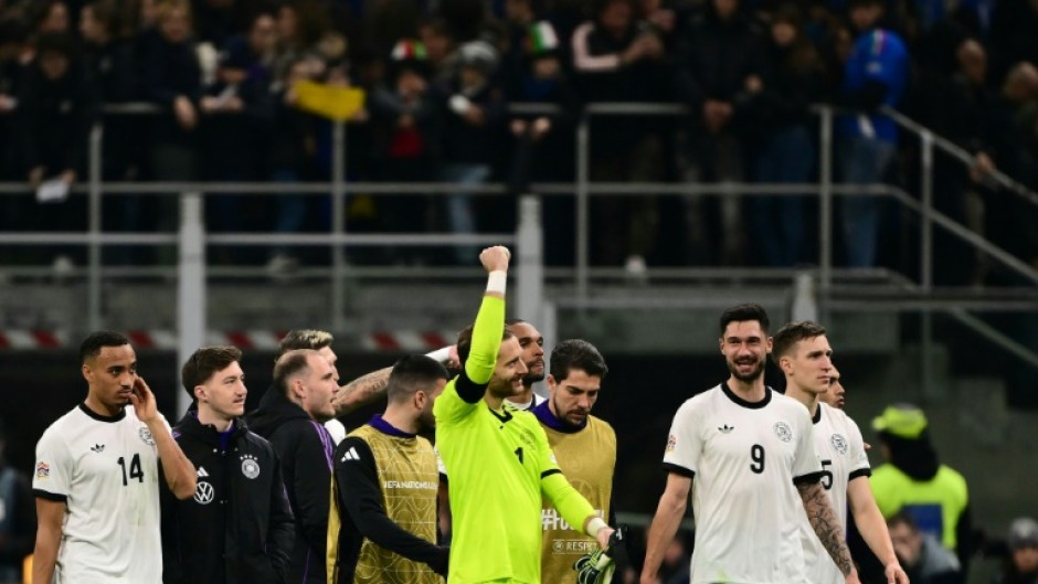 Germany goalkeeper Oliver Baumann celebrates with team-mates after winning the Nations League quarter-final first leg against Italy in Milan
