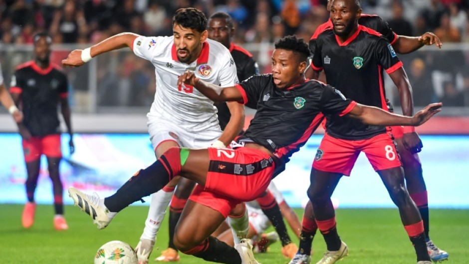 Tunisia forward Hazem Mastouri (L) is surrounded by Malawi defenders during a 2026 World Cup qualifier in Rades.