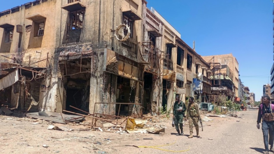Fighters loyal to the army patrol a market area in Khartoum