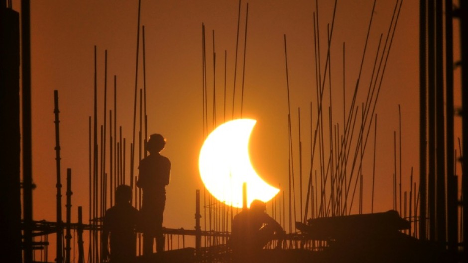 Workers at a construction site in India during 2022's partial solar eclipse