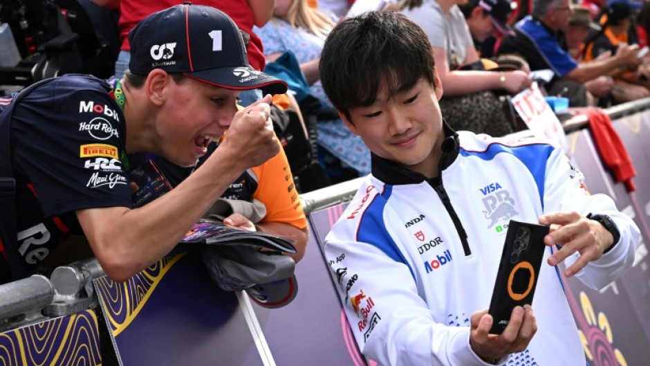 Man in demand: Yuki Tsunoda takes selfies with fans at the season-opening Australian Grand Prix
