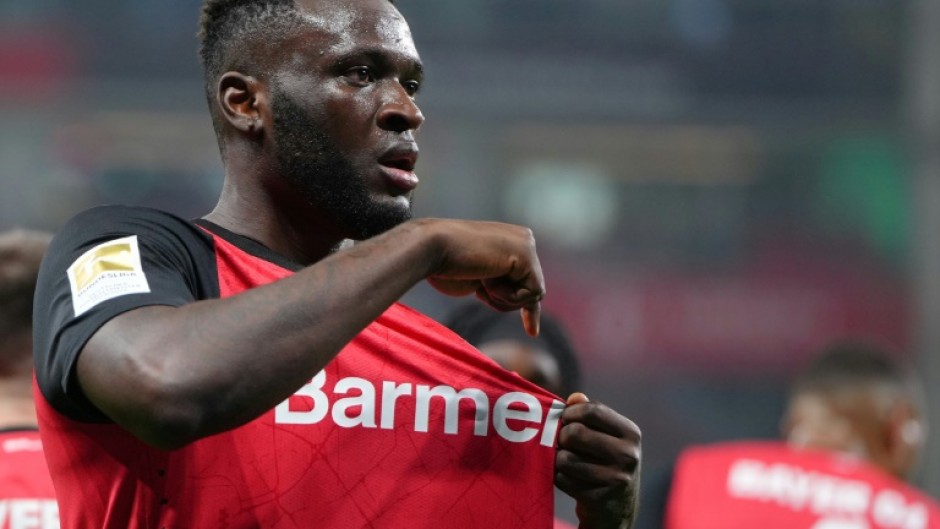 Bayer Leverkusen striker Victor Boniface points to the club's badge after scoring in Friday's 3-1 win over Bochum