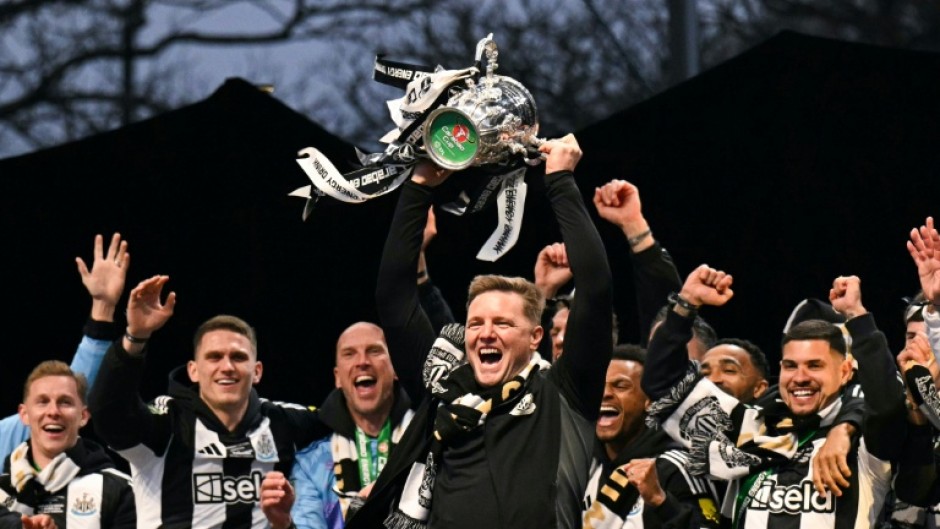 Newcastle manager Eddie Howe lifts the League Cup in front of a crowd of 150,000 celebrating fans