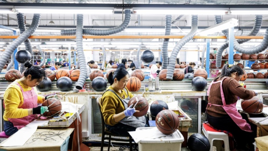 Employees produce basketballs that will be exported to Europe at a factory in Sihong, in eastern China's Jiangsu province on March 25, 2025.