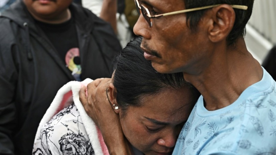Naruemol Thonglek (C) is praying her boyfriend will emerge from the rubble where a Bangkok skyscraper collapsed in the wake of a devastating earthquake in Myanmar