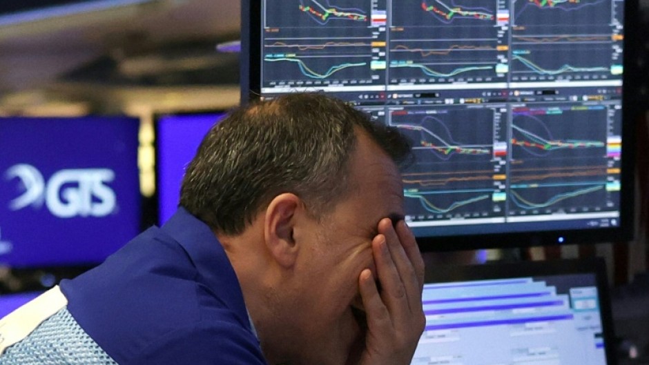 A trader winces on the floor of the New York Stock Exchange on April 4, 2025, during one of the market's worst days in years, following US President Donald Trump's imposition of import tariffs on much of the world