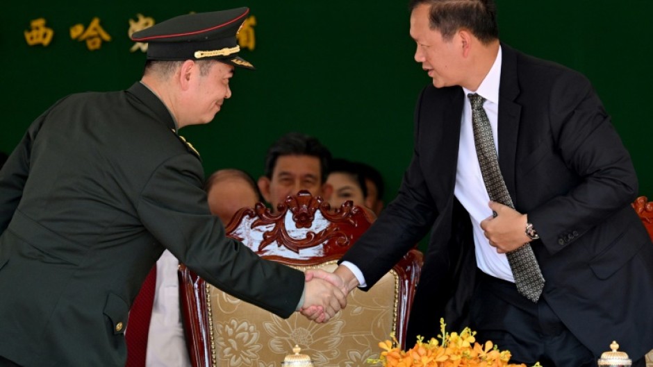 Cambodia's Prime Minister Hun Manet (R) shakes hands with Chinese general Cao Qingfeng (L) during an inauguration ceremony of the renovated Ream Naval Base in Preah Sihanouk province