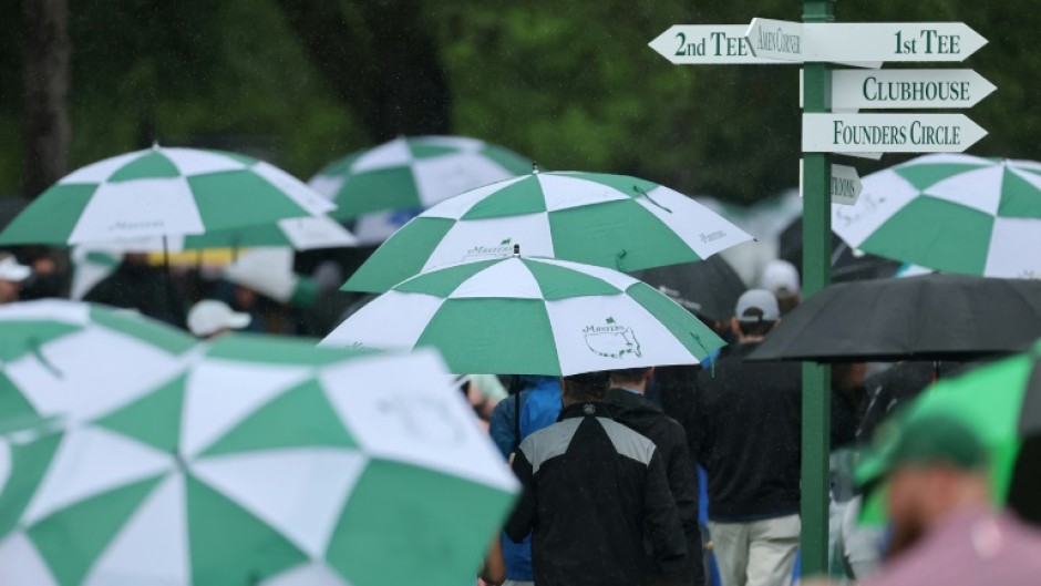 Spectators evacuate Augusta National Golf Club after bad weather halted the first official practice round for the 89th Masters