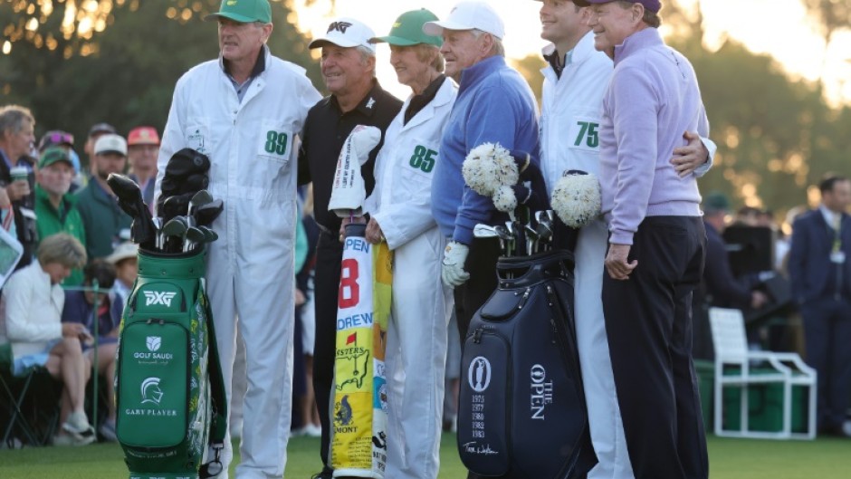 Honorary Starters Gary Player of South Africa and Americans Jack Nicklaus and Tom Watson of the United States pose with their caddies on the first tee after hitting honorary tee shots to start the 89th Masters