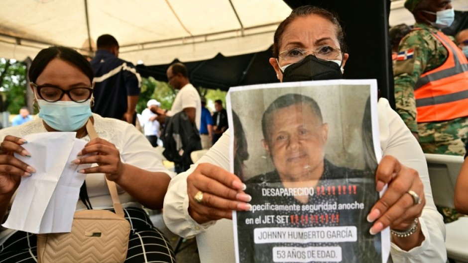 Ayuni Garcia holds a picture of her brother Johnny, who was at the club when its roof collapsed
