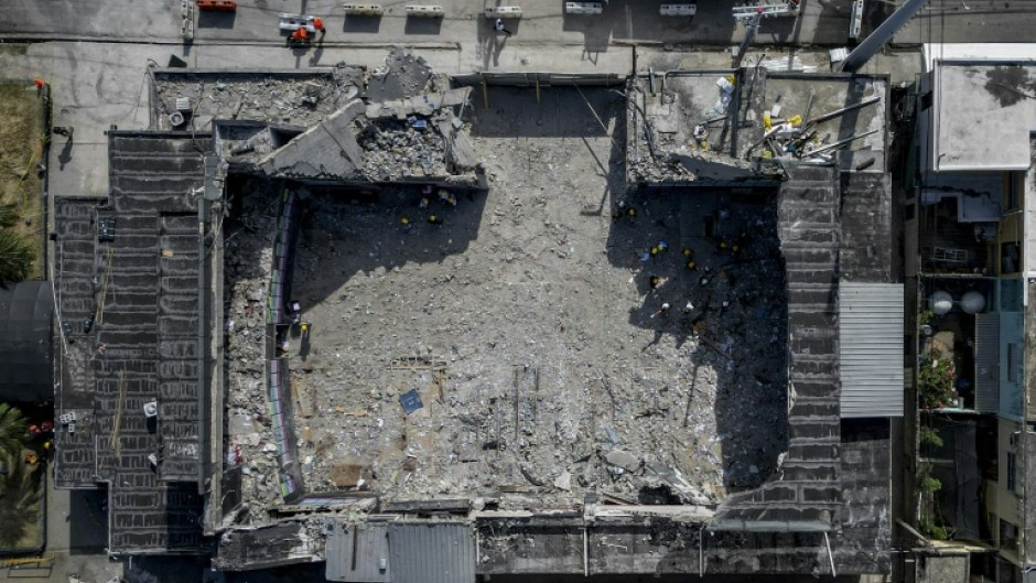 A man lights a candle in tribute to victims of the Jet Set nightclub roof collapse in Santo Domingo