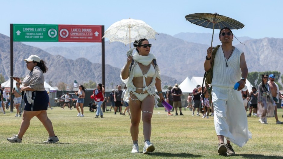 Thousands of music fans traversed the sprawling grounds whipping paper fans and wielding parasols, as temperatures cracked the 100-degree Fahrenheit mark (37.8 degrees Celsius)