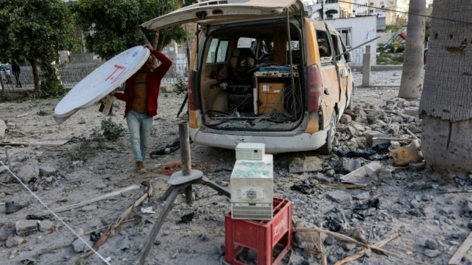 A man carries a satellite dish near a damaged media van after the strike which Israel's military said targeted Hamas militants who used the hospital facility