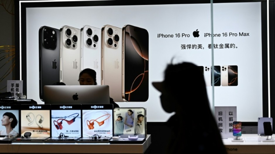 A woman walks past an electronics store at a shopping mall in Beijing on April 13, 2025