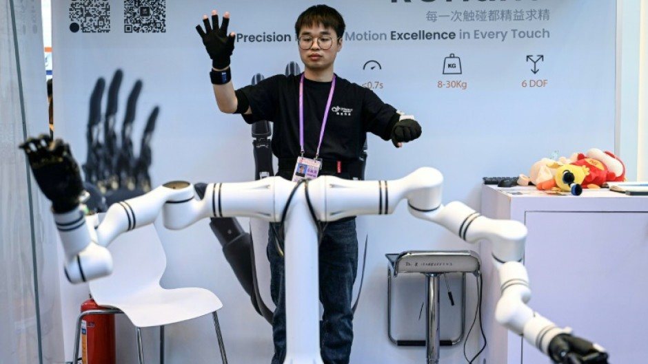 An exhibitor controls robot hands from ROhand at the Canton Fair in Guangzhou, in southern China's Guangdong province