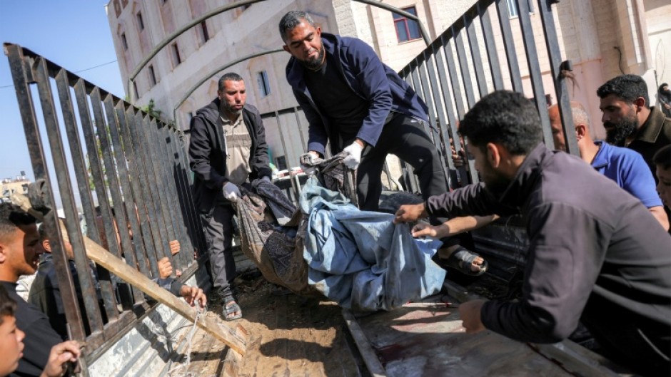 People transport from the bed of a truck the remains of a victim killed in Israeli bombardment on Jabalia, northern Gaza