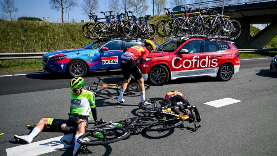 Jens Reynders (seated) and Amund Groendahl Jansen (standing) remounted after a crash in the Scheldeprijs in March. but Jonas Iversby Hvideberg (lying face down) suffered broken bones in his face and a concussion