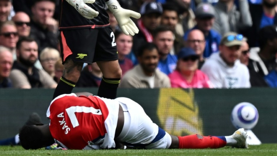 Arsenal's Bukayo Saka lies injured after Leif Davis's foul at Ipswich