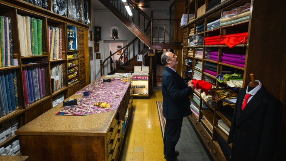 The shop's shelves are heavy with colourful bolts of fabric.