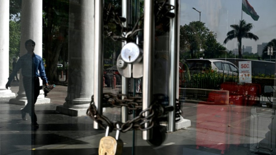 A man walks past a closed shop during a shutdown called by different trade unions to show solidarity with victims of the Pahalgam tourist attack, in New Delhi on April 25