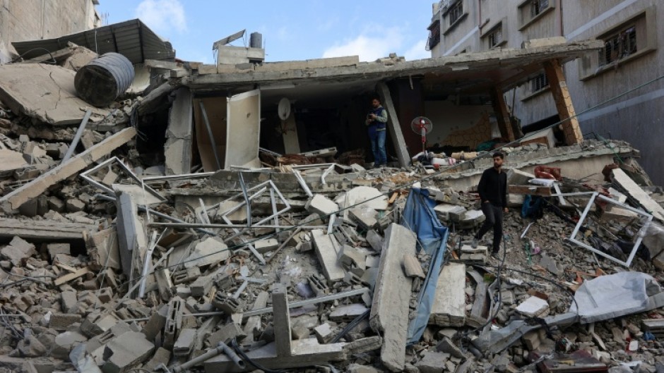 Palestinians inspect the damage after a strike hit a family home in Gaza City